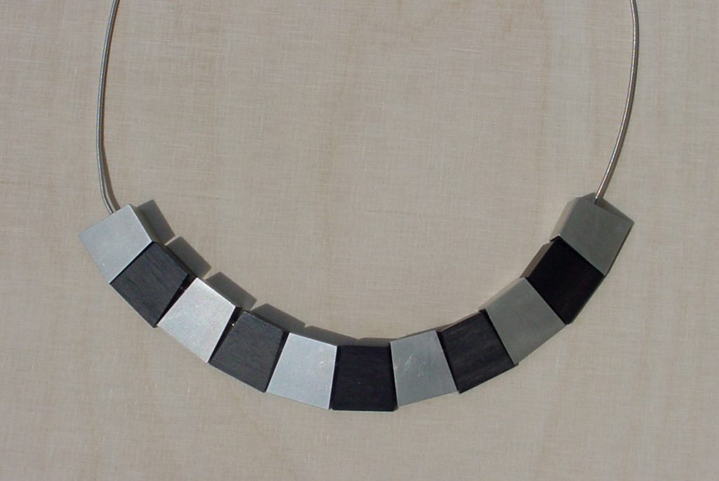 Kette schwarz silber auf Holz
